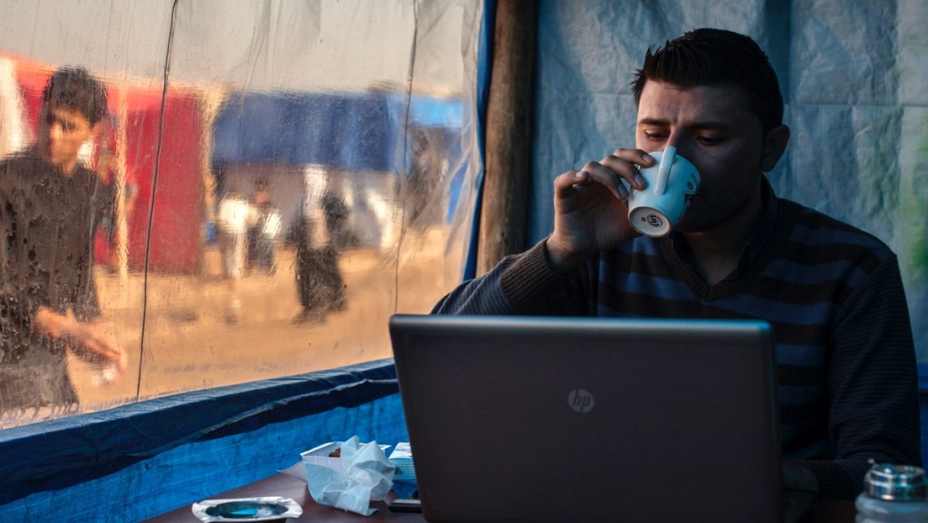 Man on laptop on the ground with coffee